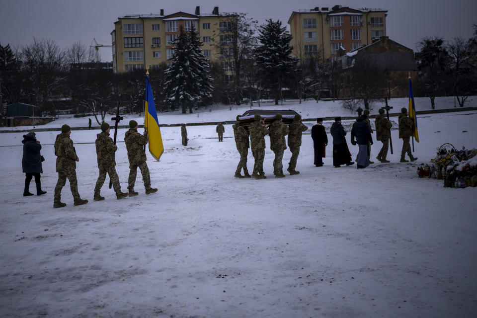 Soldiers carry the coffin of Yevhen Zapotichnyi, a Ukrainian military servicemen who were killed in the east of the country, during his funeral in Lviv, Ukraine, Tuesday, Feb 7, 2023. (AP Photo/Emilio Morenatti)