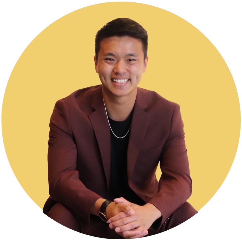 Eric Yu in a suit against a yellow background.