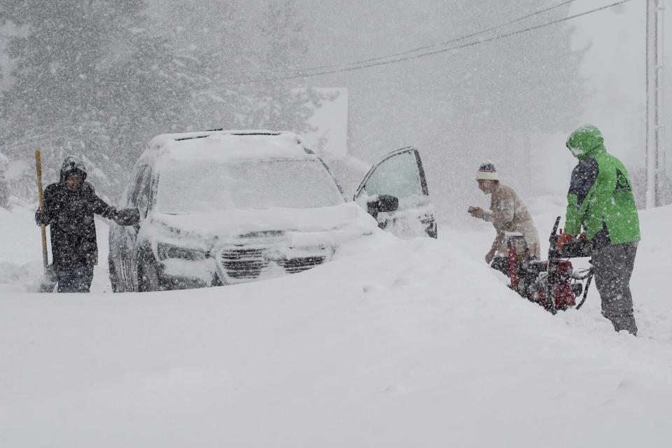 Residents try to clear snow during a storm, Saturday, March 2, 2024, in Truckee, Calif. (AP Photo/Brooke Hess-Homeier)