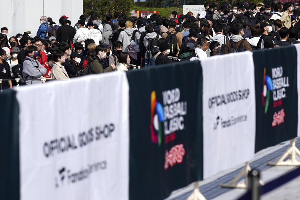 Fans queue to buy souvenir at a shop prior to the Pool B game between Japan and China at the World Baseball Classic (WBC) at the Tokyo Dome Thursday, March 9, 2023, in Tokyo. Japanese baseball player Shohei Ohtani is arguably the game's best player. But he's more than just a baseball player. He's an antidote for many in his native country. (AP Photo/Eugene Hoshiko)