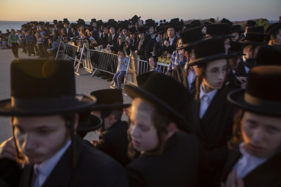 Ultra-Orthodox Jews of the Kiryat Sanz Hassidic sect listen to their rabbi on a hill overlooking the Mediterranean Sea as they participate in a Tashlich ceremony, in Netanya, Israel, Tuesday, Sept. 14, 2021. Tashlich, which means "to cast away" in Hebrew, is the practice in which Jews go to a large flowing body of water and symbolically "throw away" their sins by throwing a piece of bread, or similar food, into the water before the Jewish holiday of Yom Kippur, which starts at sundown on Wednesday. (AP Photo/Ariel Schalit)