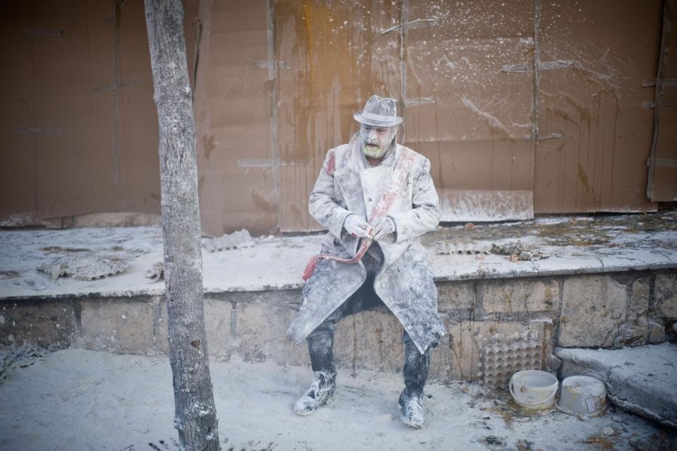 IBI, SPAIN - DECEMBER 28: A Reveller smokes during the battle of 'Enfarinats', a flour fight in celebration of the Els Enfarinats festival on December 28, 2012 in Ibi, Spain. Citizens of Ibi annually celebrate the festival with a battle using flour, eggs and firecrackers. The battle takes place between two groups, a group of married men called 'Els Enfarinats' which take the control of the village for one day pronouncing a whole of ridiculous laws and fining the citizens that infringe them and a group called 'La Oposicio' which try to restore order. At the end of the day the money collected from the fines is donated to charitable causes in the village. The festival has been celebrated since 1981 after the town of Ibi recovered the tradition but the origins remain unknown.Ê (Photo by David Ramos/Getty Images)