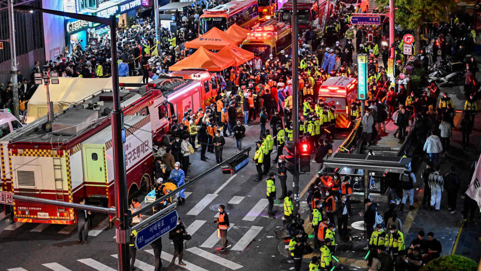 Onlookers, police and paramedics are seen in a city street.