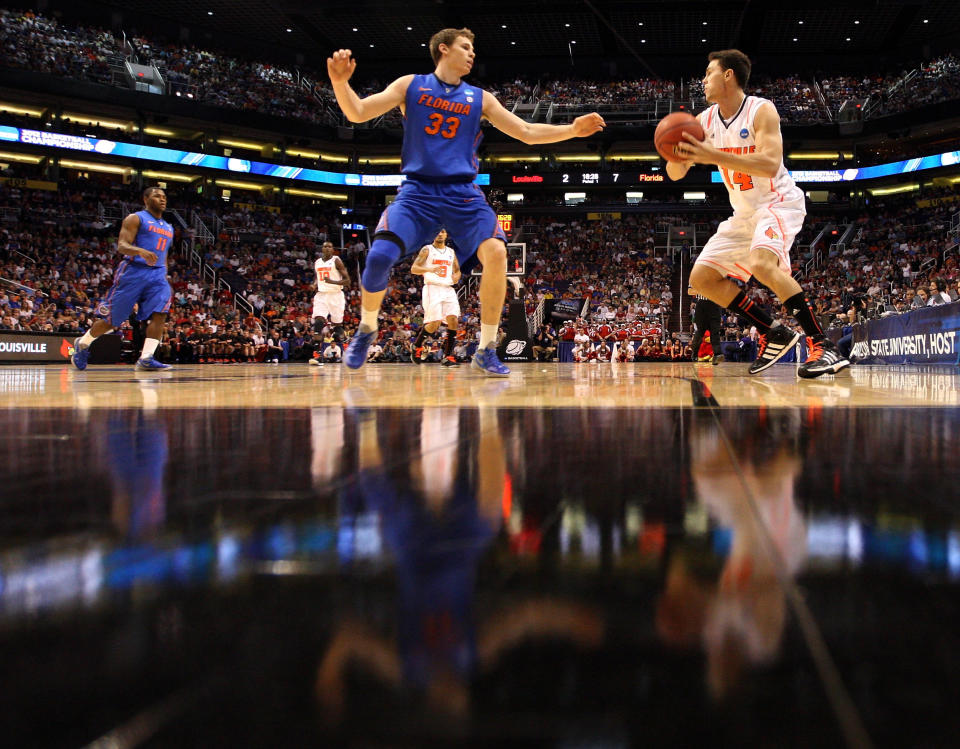 PHOENIX, AZ - MARCH 24: Kyle Kuric #14 of the Louisville Cardinals looks to shoot over Erik Murphy #33 of the Florida Gators in the first half during the 2012 NCAA Men's Basketball West Regional Final at US Airways Center on March 24, 2012 in Phoenix, Arizona. (Photo by Jamie Squire/Getty Images)