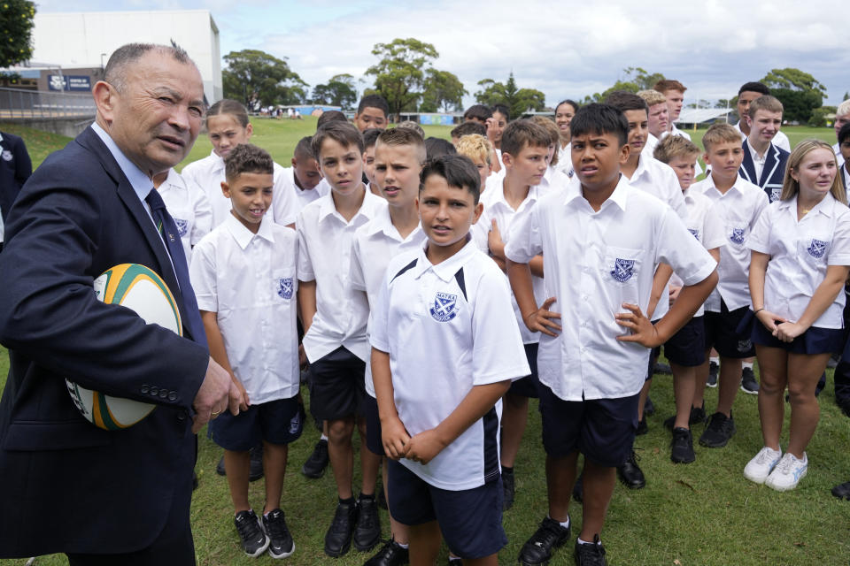 Australia's head rugby union coach Eddie Jones, left, talks with students at Matraville Sports High School in Sydney, Tuesday, Jan. 31, 2023. Jones, who was named as new coach of the Australian rugby team on Jan. 16, faced the media on Tuesday in his first appearance since returning to the Wallabies. He will lead the team at the Rugby World Cup later this year in France. (AP Photo/Rick Rycroft)