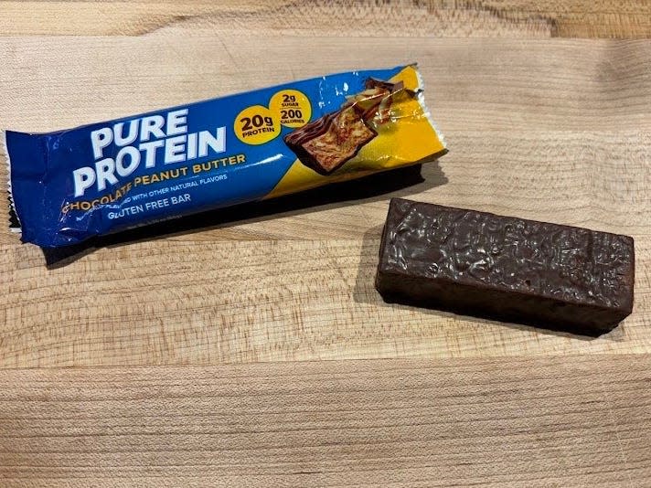 Pure Protein protein bar wrapper with unwrapped bar next to it 