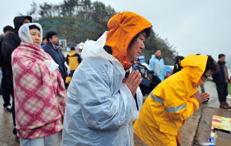South Korean relatives pray for the missing passengers of a capsized ferry at a harbor in Jindo on April 18, 2014