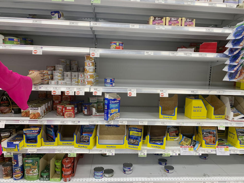 A shopper picks through canned meats at Publix grocery store ahead of Hurricane Dorian on Thursday, Aug. 29, 2019, in Pembroke Pines, Fla. (AP Photo/Brynn Anderson)