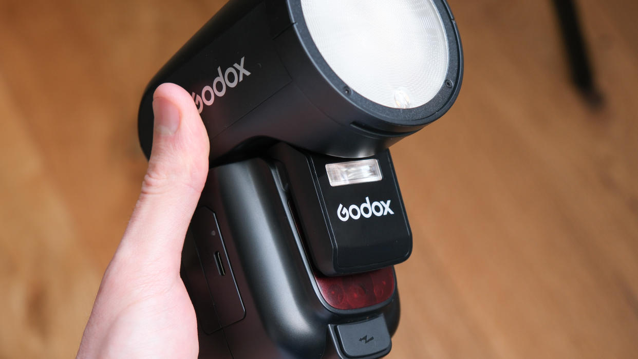  Godox V1Pro flashgun held in a hand. 