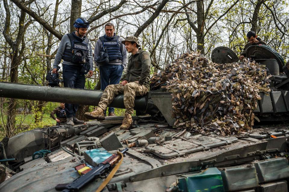 AFP visual journalist Arman Soldin, left, and fixer Oleksiy Obolensky, center, chat with a Ukrainian soldier in Donbass region on April 29, 2022.