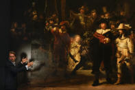 Museum director Taco Dibbits explains how Rembrandt's biggest painting the Night Watch just got bigger with the help of artificial intelligence in Amsterdam, Netherlands, Wednesday, June 23, 2021. Right above Dibbits, left, one of the added parts is seen, the Dutch national museum and art gallery reveals findings from a long-term project to examine in minute detail Rembrandt van Rijn's masterpiece the Night Watch. (AP Photo/Peter Dejong)