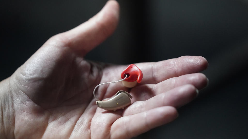 Chelle Wyatt holds her hearing aid Friday, April 15, 2022, in Salt Lake City. People with hearing loss have adopted technology to navigate the world, especially as hearing aids are expensive and inaccessible to many. (AP Photo/Rick Bowmer)