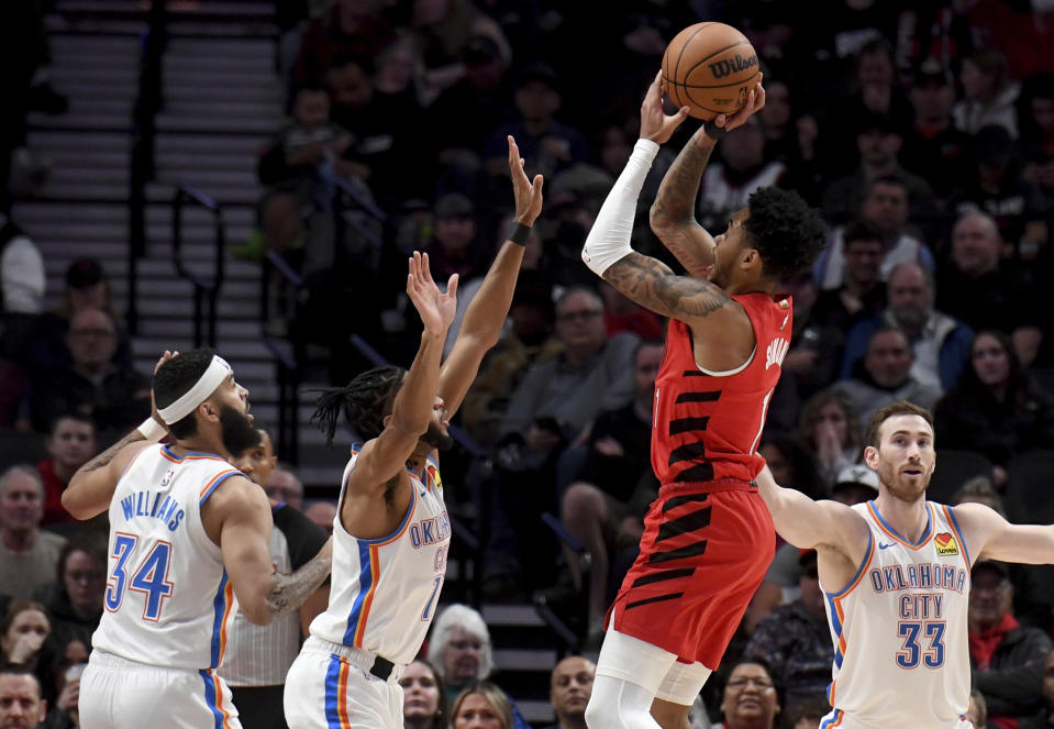 Portland Trail Blazers guard Anfernee Simons, second from right, hits a shot over Oklahoma City Thunder guard Isaiah Joe, second from right, as forward Kenrich Williams, left, and forward Gordon Hayward, right, look on during the first half of an NBA basketball game in Portland, Ore., Wednesday, March 6, 2024. (AP Photo/Steve Dykes)