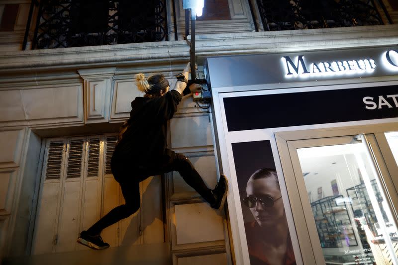 Un activista del equipo de parkour "On the Spot" sube a un edificio en una noche en la que se apagan las luces de decenas de escaparates para concienciar sobre el ahorro de energía y la reducción de la contaminación lumínica en París