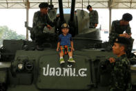 A boy sits on a tank to pose for a picture during Children's Day celebration at a military facility in Bangkok, Thailand January 14, 2017. REUTERS/Jorge Silva