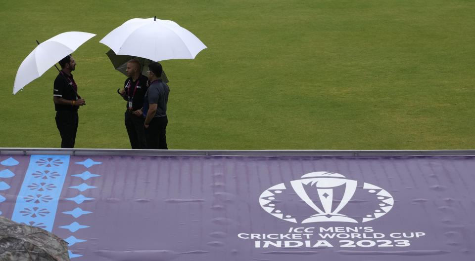 Officials and umpires talk after inspecting the ground following heavy rains that delay the start of ICC Men's Cricket World Cup warm up match between Afghanistan and South Africa in Thiruvananthapuram, India, Friday, Sept. 29, 2023. (AP Photo/Manish Swarup)