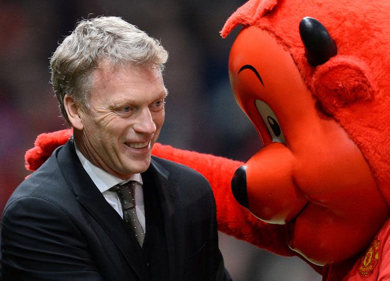 Manchester United manager David Moyes meets mascot Fred the Red as he takes his seat before the English FA Cup third round football match between Manchester United and Swansea City at Old Trafford in Manchester, northwest England, on January 5, 2014