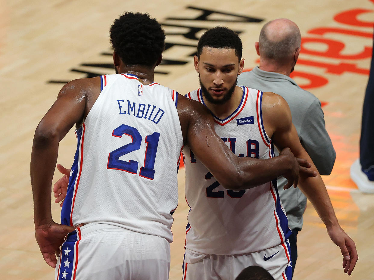 Joel Embiid and Ben Simmons hug.