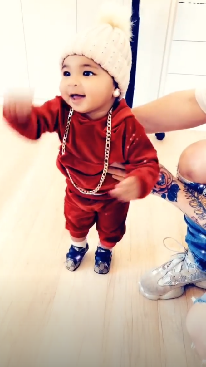 Too hip to handle! True looked adorable in a red sweatsuit, blue Gucci sneakers and a gold chain, topping off her festive V-Day look with a fuzzy white beanie.