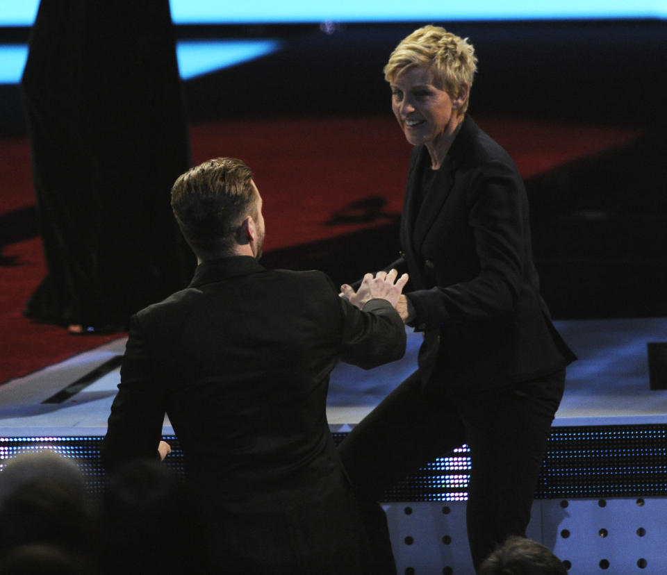 Justin Timberlake, left, congratulates Ellen DeGeneres, winner of the favorite daytime TV host award, as she walks on stage at the 40th annual People's Choice Awards at the Nokia Theatre L.A. Live on Wednesday, Jan. 8, 2014, in Los Angeles. (Photo by Chris Pizzello/Invision/AP)