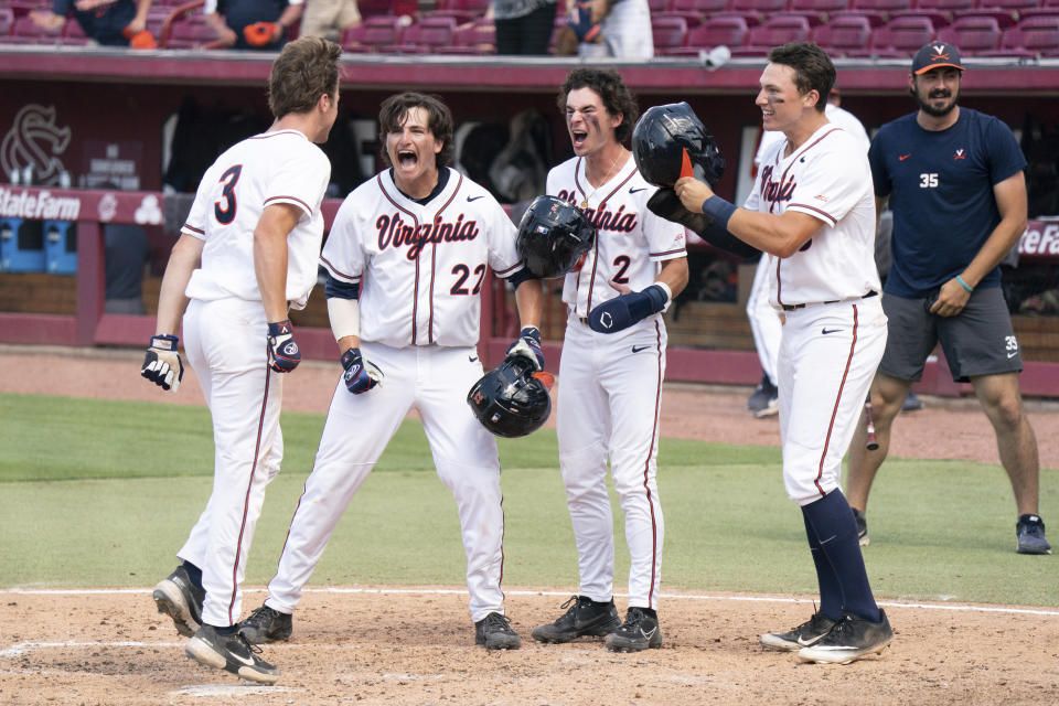Virginia's Kyle Teel (3) steps on home plate after hitting a grand slam as Jake Gelof (22), Max Cotier (2), and Zack Gelof, front right, celebrate during an NCAA college baseball tournament super regional game against Dallas Baptist, Monday, June 14, 2021, in Columbia, S.C. (AP Photo/Sean Rayford)