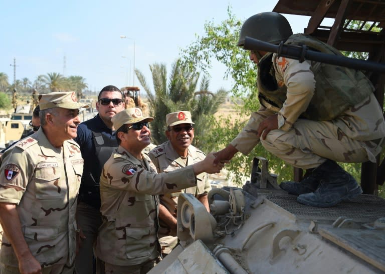 File picture released by the Egyptian Presidency shows President Abdel Fattah al-Sisi (C) shaking hands with a member of the security forces during a visit to the Sinai Peninsula