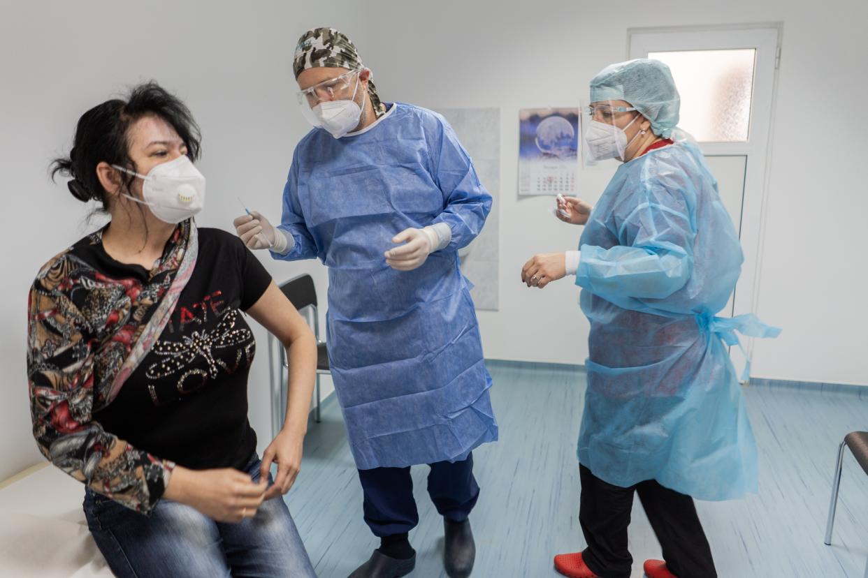 Doctor Dimitar Nikolakov, center, prepares to inject Doctor Georgieva, left, with the Pfizer-BioNTech COVID-19 vaccine at St. Anna Hospital on Jan. 6, 2021, in Sofia, Bulgaria. Bulgaria's vaccination campaign began on December 27 with medical workers included among the priority groups.