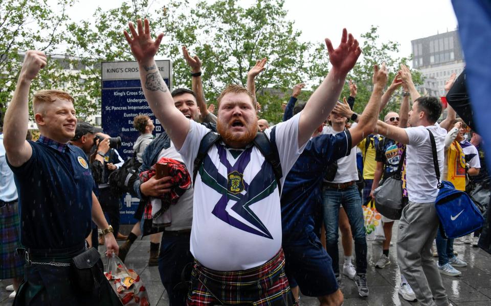 Scotland fans enjoy themselves in the pouring rain - AP