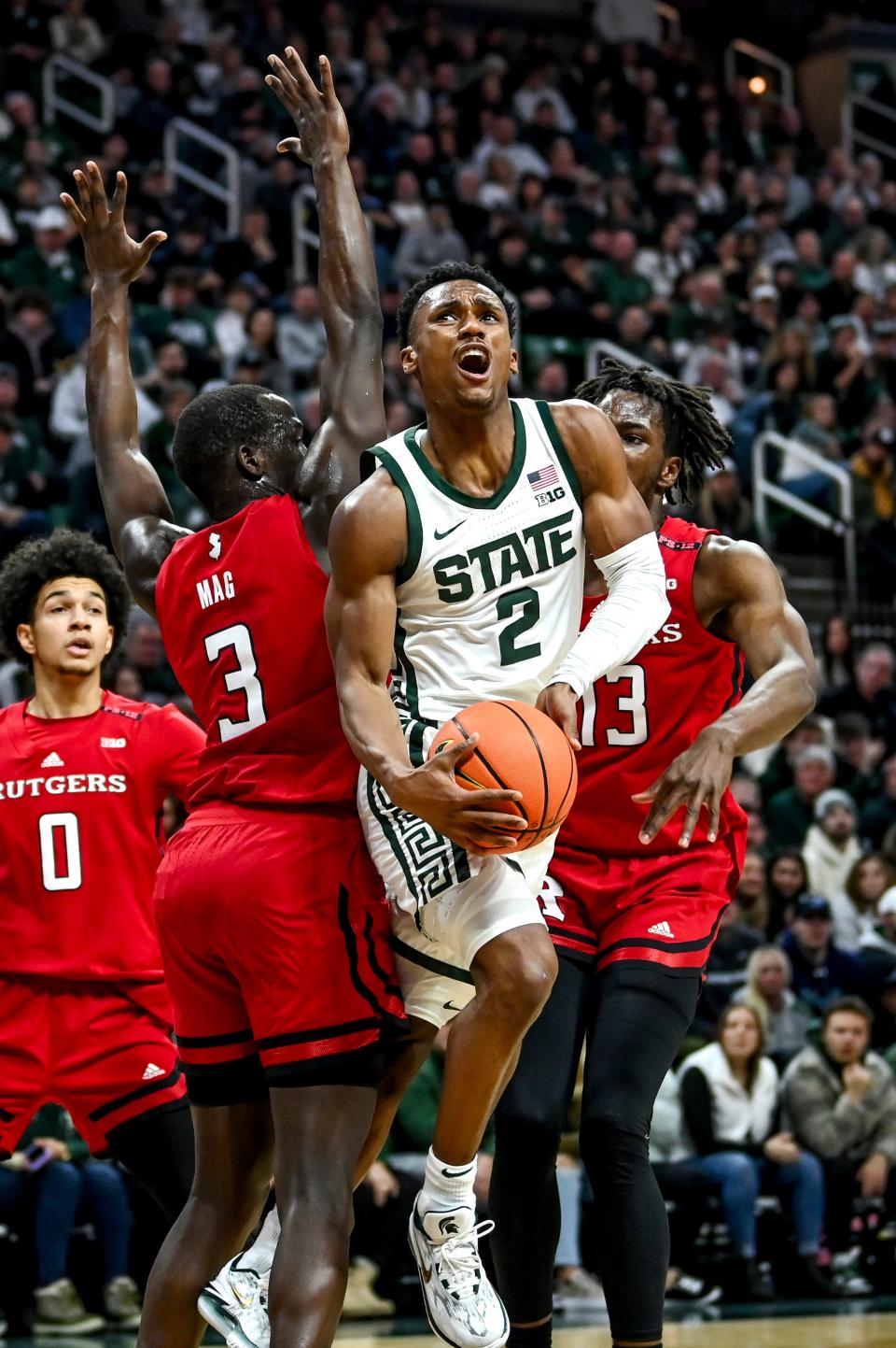 Michigan State's Tyson Walker is fouled while shooting between Rutgers' Mawot Mag, left, and Antwone Woolfolk during the first half on Sunday, Jan. 14, 2024, at the Breslin Center in East Lansing.