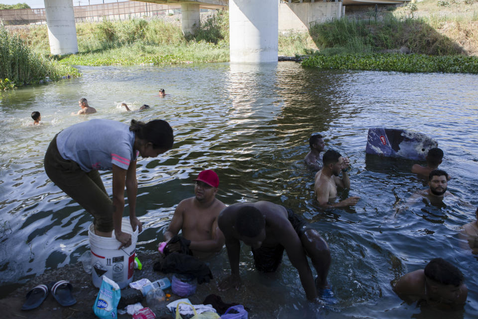 Migrants swim in a river near a shelter encampment in the border town of Matamoros, Mexico, Wednesday, Aug. 16, 2023. Mexico’s immigration agency and a Catholic aid group have opened a temporary outdoor shelter for migrants living in camps to move to, as Mexico’s National Institute for Migration wants this large camp in Matamoros dismantled. (AP Photo/Jacky Muniello)