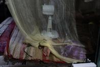 Do Hoang Trung, who lives on a houseboat with his twin sister and their grandmother, sleeps under a mosquito net in Can Tho, Vietnam, Wednesday, Jan. 17, 2024. After their mother left to pursue better opportunities in Ho Chi Minh City, Trung and his sister remained in the care of their grandmother, who supports the family by selling steamed buns at a floating market. (AP Photo/Jae C. Hong)