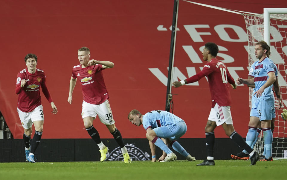 Manchester United's Scott McTominay, centre, celebrates after his team's first goal during the English Premier League soccer match between Manchester United and West Ham United at Old Trafford, Manchester, England, Sunday, March. 14, 2021. (AP Photo/Dave Thompson,Pool)