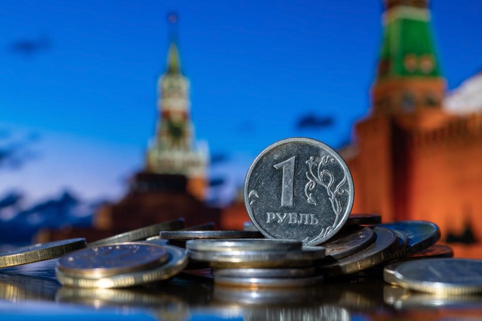 One Russian ruble against the background of the towers of the Moscow Kremlin.