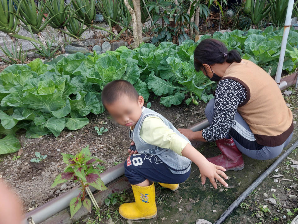 阿嬤一邊農忙還要一邊照顧年幼阿喻和弟弟。(台灣世界展望會提供)