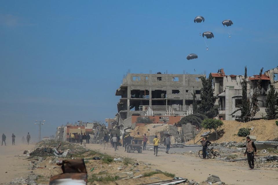 Humanitarian aid parcels attached to parachutes are airdropped from military aircraft over Gazaon 21 March (AFP via Getty Images)