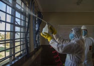 Disinfection team disinfect a classroom at Ivory Park Secondary School east of Johannesburg, South Africa, Thursday, May 28, 2020, ahead of the June 1, 2020, re-opening of Grade 7 and 12 learners to school.(AP Photo/Themba Hadebe)