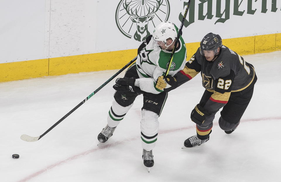 Dallas Stars' Radek Faksa (12) and Vegas Golden Knights' Nick Holden (22) battle for the puck during the second period of an NHL hockey playoff game Monday, Aug. 3, 2020 in Edmonton, Alberta. (Jason Franson/The Canadian Press via AP)