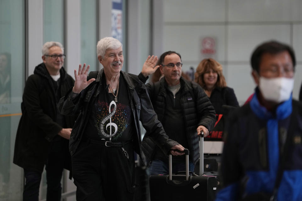 Philadelphia Orchestra's 73-year-old violinist Davyd Booth, second left, waves as he walks ahead of our members upon arriving at the Beijing Capital International Airport on Tuesday, Nov. 7, 2023. Musicians from the Philadelphia Orchestra arrived in Beijing on Tuesday, launching a tour commemorating its historic performance in China half a century ago in signs of improving bilateral ties ahead of a highly anticipated meeting between President Joe Biden and Xi Jinping. (AP Photo/Ng Han Guan)