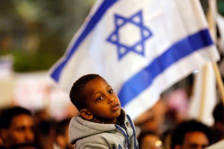 FILE PHOTO: A boy takes part in a protest against the Israeli government’s plan to deport African migrants, in Tel Aviv, Israel March 24, 2018. REUTERS/Corinna Kern/File Photo