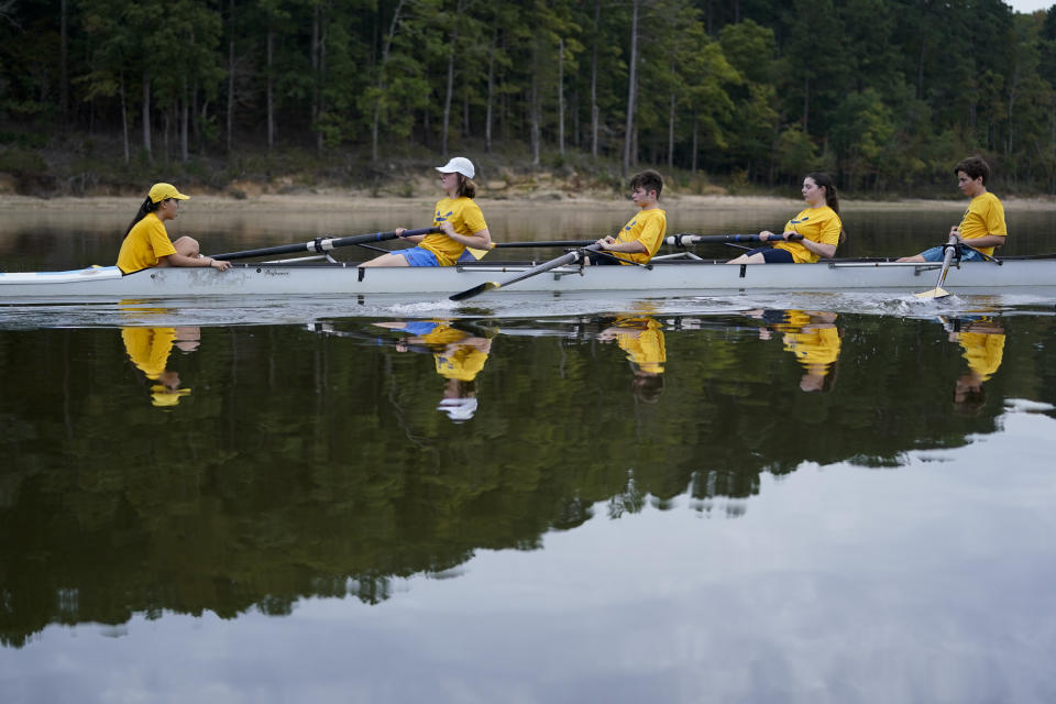 Callum Bradford, center, with other members of his club team, row during a practice at Jordan Lake, Friday, Oct. 6, 2023, in Apex, N.C. Bradford, a transgender teen from Chapel Hill needed mental health care after overdosing on prescription drugs. He was about to be transferred to another hospital due to a significant bed shortage. A North Carolina hospital network is referring transgender psychiatric patients to treatment facilities that do not align with their gender identities. Though UNC Hospitals policy discourages the practice, administrators say a massive bed shortage is forcing them to make tough decisions. (AP Photo/Erik Verduzco)