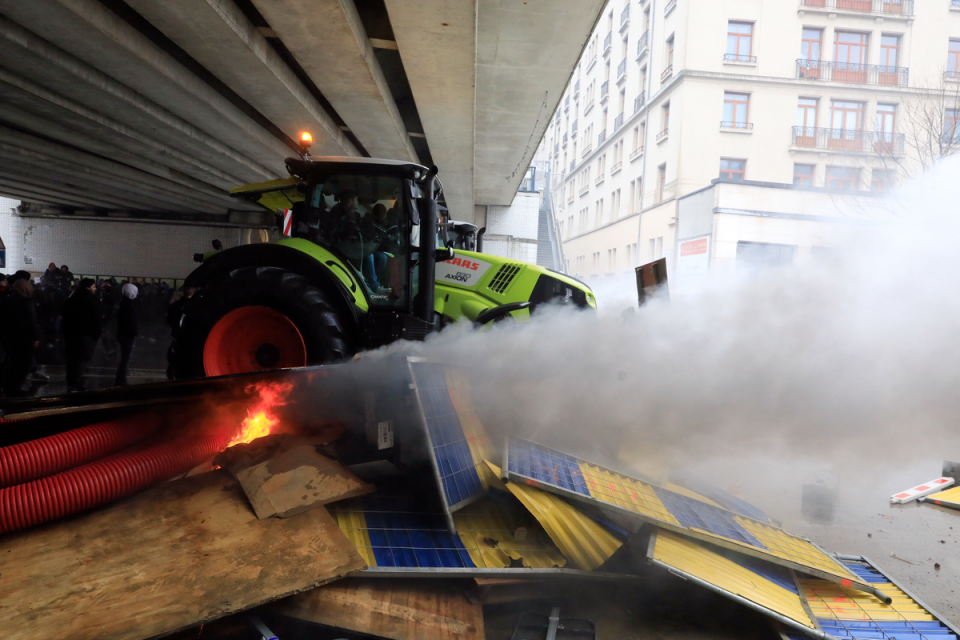 A tractor charges a barricade during a farmers demonstration outside a meeting of EU agriculture ministers in Brussels, on Monday (AP)