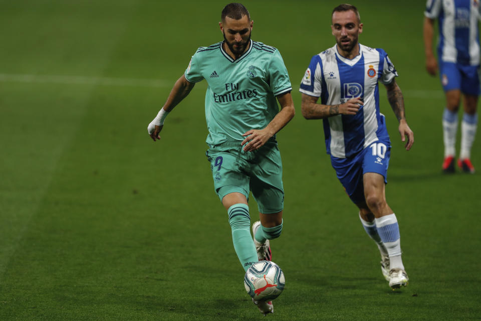 Real Madrid's Karim Benzema, left, runs past Espanyol's Sergi Darder during the Spanish La Liga soccer match between RCD Espanyol and Real Madrid at the Cornella-El Prat stadium in Barcelona, Spain, Sunday, June 28, 2020. (AP Photo/Joan Monfort)