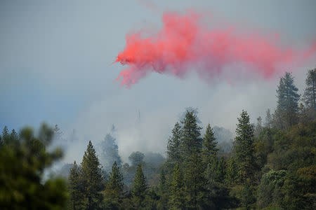 Retardant, dropped by a plane, drifts down on flames at the Ponderosa Fire east of Oroville, California, U.S. August 30, 2017. REUTERS/Noah Berger