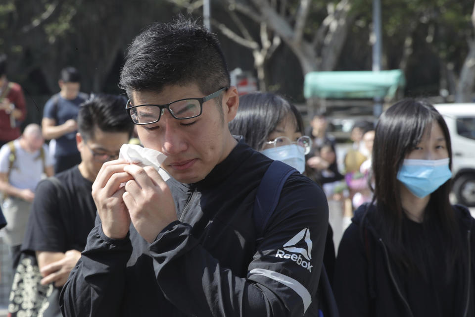 A man cries as he attends a makeshift memorial for Chow Tsz-Lok after a graduation ceremony was disrupted at the University of Science and Technology in Hong Kong on Friday, Nov. 8, 2019. Chow, a student from the University who fell off a parking garage after police fired tear gas during clashes with anti-government protesters died Friday, in a rare fatality after five months of unrest that intensified anger in the semi-autonomous Chinese territory. (AP Photo/Kin Cheung)