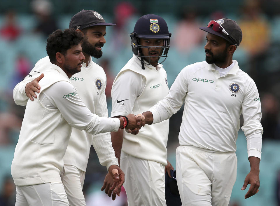 India's Kuldeep Yadav, left, is congratulated by teammates after he took 5 wickets against Australia on day 4 of their cricket test match in Sydney, Sunday, Jan. 6, 2019. (AP Photo/Rick Rycroft)