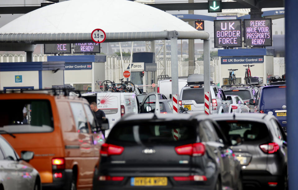 People queue in line to check-in for the cross channel ferry in Calais, France, Friday Aug.14, 2020. British holiday makers in France were mulling whether to return home early Friday to avoid having to self-isolate for 14 days following the U.K. government's decision to reimpose quarantine restrictions on France amid a recent pick-up in coronavirus infections. (AP Photo/Olivier Matthys)