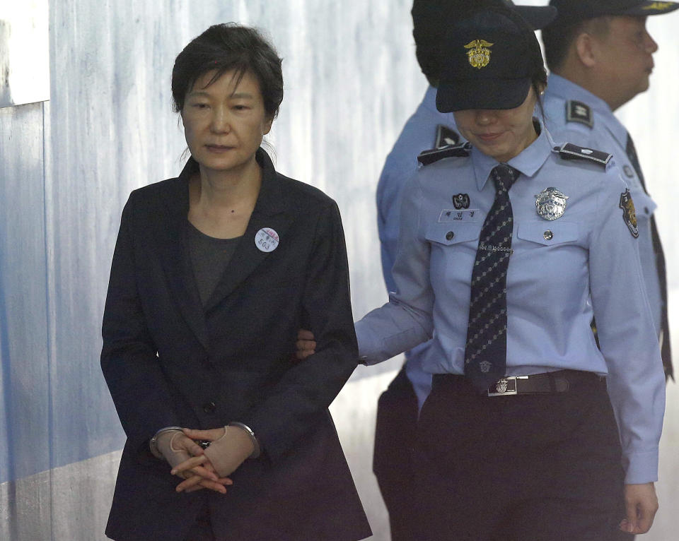 FILE - In this Oct. 10, 2017, file photo, former South Korean President Park Geun-hye, left, arrives to attend a hearing on the extension of her detention at the Seoul Central District Court in Seoul, South Korea. Prosecutors on Tuesday, Feb. 27, 2018 have demanded a 30-year prison term for Park for alleged bribery, abuse of power and other crimes in a landmark corruption case that marked a stunning fall from grace for the country’s first female leader and former conservative icon. (AP Photo/Ahn Young-joon, File)