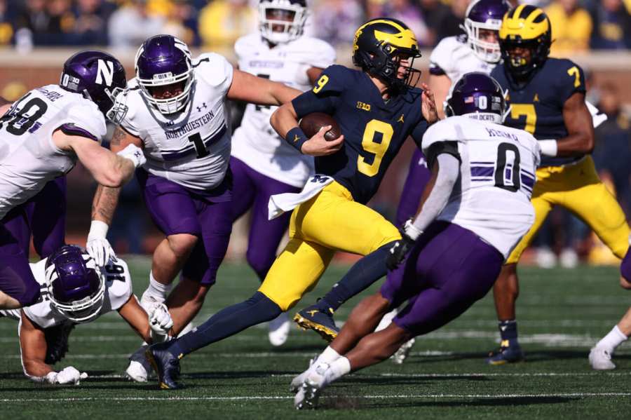 J.J. McCarthy #9 of the Michigan Wolverines looks for yards during a second half run against the Northwestern Wildcats at Michigan Stadium on October 23, 2021 in Ann Arbor, Michigan. Michigan won the game 33-7. (Photo by Gregory Shamus/Getty Images)