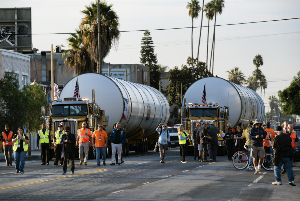 Trucks haul two rocket motors slowly down Figueroa Street in Los Angeles, Wednesday Oct. 11, 2023. The giant rocket motors, required to display the retired NASA space shuttle Endeavour as if it’s about to blast off, were trucked over two days from Mojave Air and Space Port to LA’s Exposition Park. (AP Photo/Richard Vogel)
