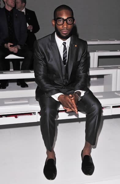 <b>Tinie Tempah</b><br><br>The rapper donned a shiny grey suit, striped tie and signature specs for the Lee Roach fashion show.